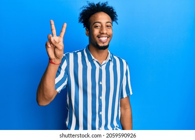 Young african american man with beard wearing casual striped shirt showing and pointing up with fingers number two while smiling confident and happy. 