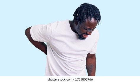 Young African American Man With Braids Wearing Casual White Tshirt Suffering Of Backache, Touching Back With Hand, Muscular Pain 