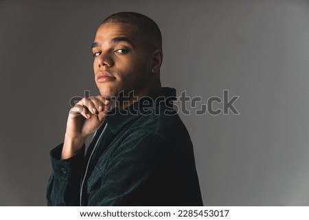Young African American man with buzz cut on a grey dark studio background . High quality photo