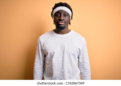 Young african american man doing sport wearing sportswer over isolated yellow background with serious expression on face. Simple and natural looking at the camera. - Powered by Shutterstock