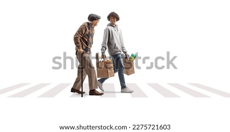 Young african american man helping a senior with grocery bags at a pedestrian crossing isolated on white background