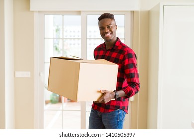 Young african american man holding a carton box, packing cardboard delivery package at home