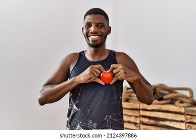 Young African American Man Holding Heart Training At Sport Center