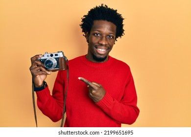 Young African American Man Holding Vintage Camera Smiling Happy Pointing With Hand And Finger 