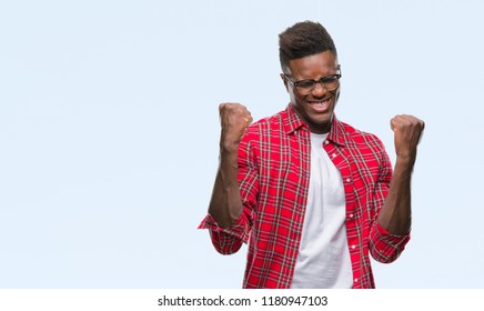 Young african american man over isolated background very happy and excited doing winner gesture with arms raised, smiling and screaming for success. Celebration concept.