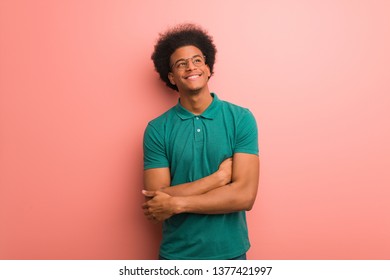 Young African American Man Over A Pink Wall Smiling Confident And Crossing Arms, Looking Up