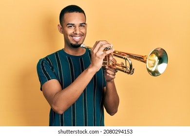 Young African American Man Playing Trumpet Smiling With A Happy And Cool Smile On Face. Showing Teeth. 