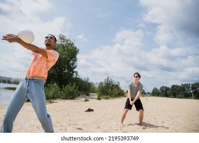 Young African American Man Playing Beach Volleyball With Friend