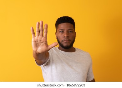 Young African American Man Shown Hand On Sign For Them To Stop With Racial Prejudice.
