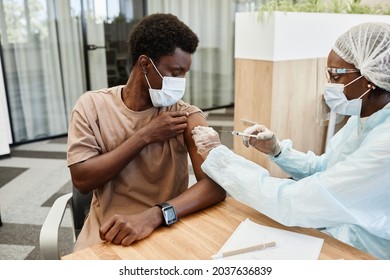 Young African American Man Sitting At Doctors Office And Getting Flu Shot In His Arm