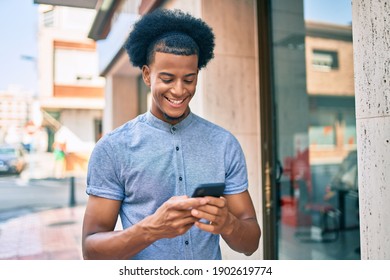 Young African American Man Smiling Happy Using Smartphone At The City.