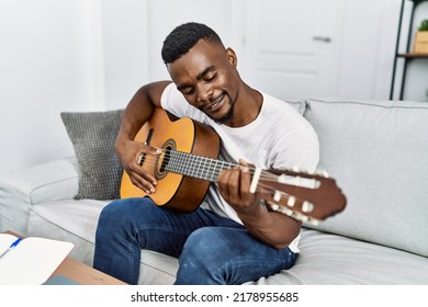 Young African American Man Smiling Confident Playing Guitar At Home