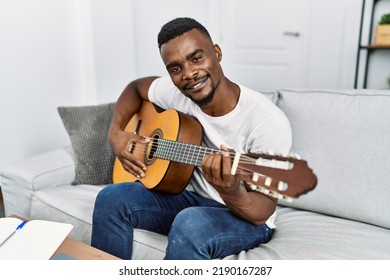 Young African American Man Smiling Confident Playing Guitar At Home