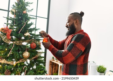 Young african american man smiling confident decorating christmas tree at home - Powered by Shutterstock