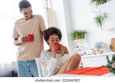 Young African American Man Smiling Near Sexy Girlfriend Drinking Morning Coffee With Closed Eyes