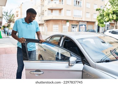 Young african american man smiling confident standing by car at street - Powered by Shutterstock