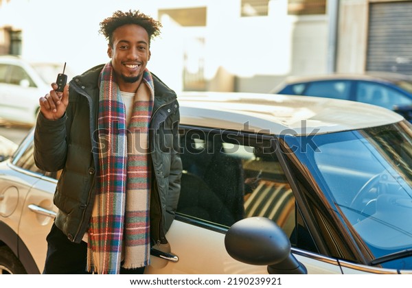 Young african american man smiling happy holding key\
car at the city
