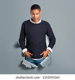 Young African American Man Standing And Looking Down Through A Paper Hole