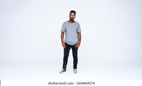 Young African American Man Standing Isolated On White Background. Young Man In Eyeglasses And Casual Clothes Looking At Camera .