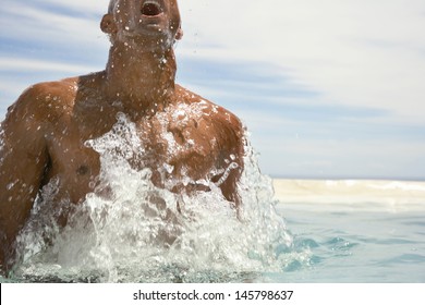 Young African American Man Surfacing In Swimming Pool