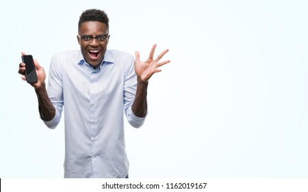 Young African American Man Using Smartphone Very Happy And Excited, Winner Expression Celebrating Victory Screaming With Big Smile And Raised Hands