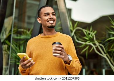 Young African American Man Using Smartphone Drinking Coffee At The City.