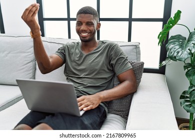 Young African American Man Using Laptop At Home Sitting On The Sofa Doing Italian Gesture With Hand And Fingers Confident Expression 