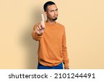 Young african american man wearing casual clothes pointing with finger up and angry expression, showing no gesture 