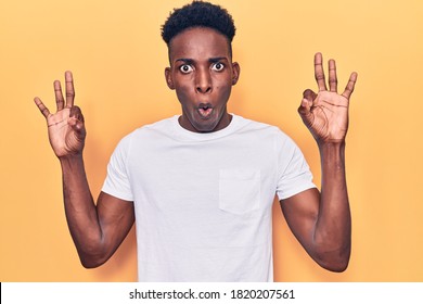 Young african american man wearing casual clothes looking surprised and shocked doing ok approval symbol with fingers. crazy expression 