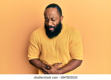 Young african american man wearing casual clothes with hand on stomach because nausea, painful disease feeling unwell. ache concept. 