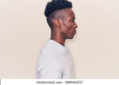 Young African American Man Wearing Casual Clothes Looking To Side, Relax Profile Pose With Natural Face With Confident Smile. 