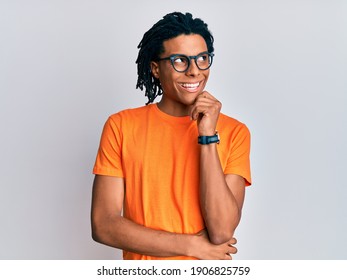 Young african american man wearing casual clothes and glasses with hand on chin thinking about question, pensive expression. smiling with thoughtful face. doubt concept.  - Powered by Shutterstock