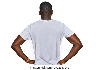 Young african american man wearing casual white t shirt standing backwards looking away with arms on body  - Powered by Shutterstock