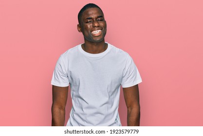 Young African American Man Wearing Casual White T Shirt Winking Looking At The Camera With Sexy Expression, Cheerful And Happy Face. 