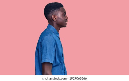 Young African American Man Wearing Casual Clothes Looking To Side, Relax Profile Pose With Natural Face And Confident Smile. 