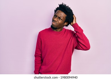 Young african american man wearing casual clothes confuse and wondering about question. uncertain with doubt, thinking with hand on head. pensive concept. 