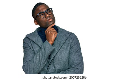 Young African American Man Wearing Business Clothes And Glasses With Hand On Chin Thinking About Question, Pensive Expression. Smiling With Thoughtful Face. Doubt Concept. 