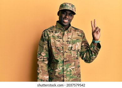 Young african american man wearing army uniform smiling looking to the camera showing fingers doing victory sign. number two. 