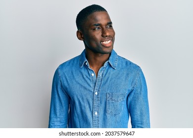 Young African American Man Wearing Casual Clothes Looking To Side, Relax Profile Pose With Natural Face And Confident Smile. 