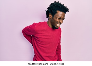 Young african american man wearing casual clothes suffering of backache, touching back with hand, muscular pain  - Shutterstock ID 2050012181