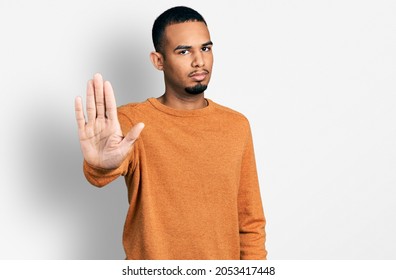 Young african american man wearing casual clothes doing stop sing with palm of the hand. warning expression with negative and serious gesture on the face.