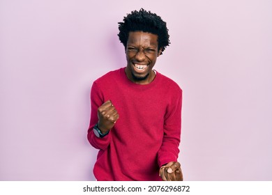 Young african american man wearing casual clothes celebrating surprised and amazed for success with arms raised and eyes closed. winner concept.  - Shutterstock ID 2076296872