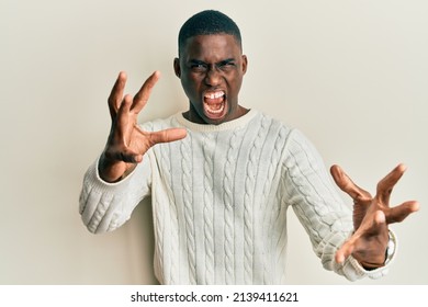 Young African American Man Wearing Casual Clothes Shouting Frustrated With Rage, Hands Trying To Strangle, Yelling Mad 