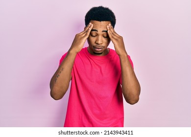 Young african american man wearing casua t shirt with hand on head for pain in head because stress. suffering migraine.  - Powered by Shutterstock