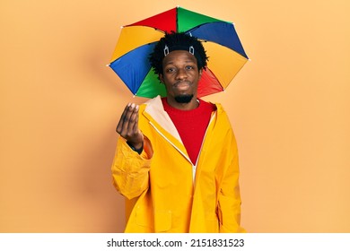 Young African American Man Wearing Yellow Raincoat Doing Italian Gesture With Hand And Fingers Confident Expression 