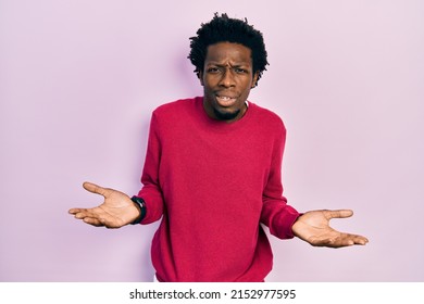 Young African American Man Wearing Casual Clothes Clueless And Confused With Open Arms, No Idea Concept. 
