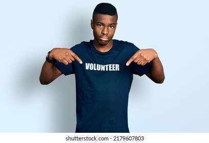 Young African American Man Wearing Volunteer T Shirt Pointing Down Looking Sad And Upset, Indicating Direction With Fingers, Unhappy And Depressed. 