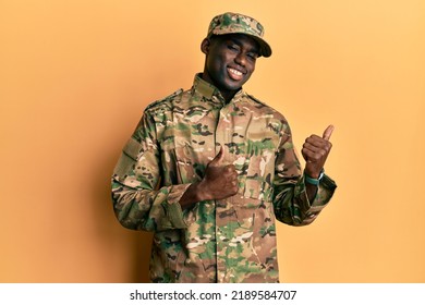 Young african american man wearing army uniform pointing to the back behind with hand and thumbs up, smiling confident  - Powered by Shutterstock