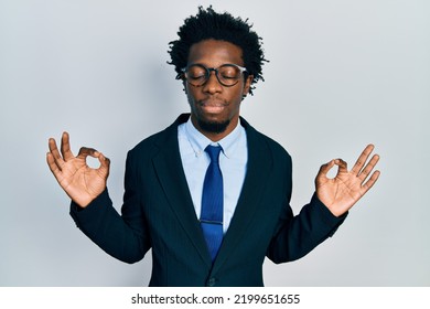 Young African American Man Wearing Business Suit Relax And Smiling With Eyes Closed Doing Meditation Gesture With Fingers. Yoga Concept. 