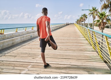 Young african american man wearing sportswear stretching at seaside - Powered by Shutterstock